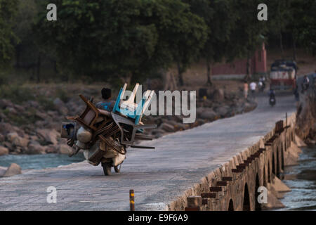 Mann trägt Plastikstühle auf einem Motorrad, Orchha, Indien Stockfoto