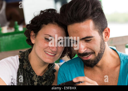 Mann und Frau betrachten von Bildern auf einer Kompaktkamera. Stockfoto