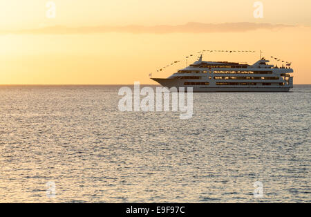 Kreuzfahrtschiff fährt nach Sonnenuntergang Stockfoto