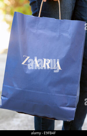 Paphos, Zypern - 20. Dezember 2013 Frau stehen auf der Straße mit Zara Papiertüte in ihrer Hand. Urban-Szene. Stockfoto