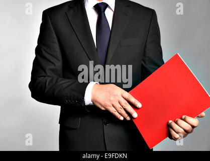 Geschäftsmann hält eine Broschüre Stockfoto