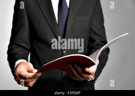 Geschäftsmann hält eine Broschüre Stockfoto