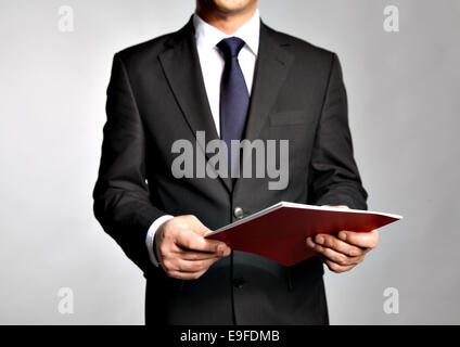 Geschäftsmann hält eine Broschüre Stockfoto