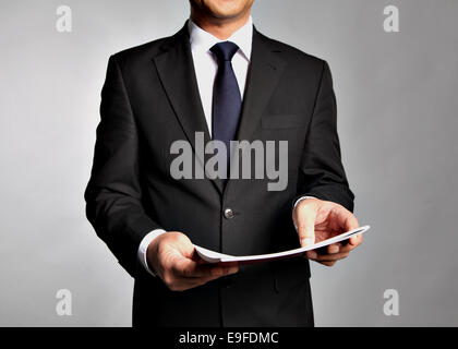 Geschäftsmann hält eine Broschüre Stockfoto