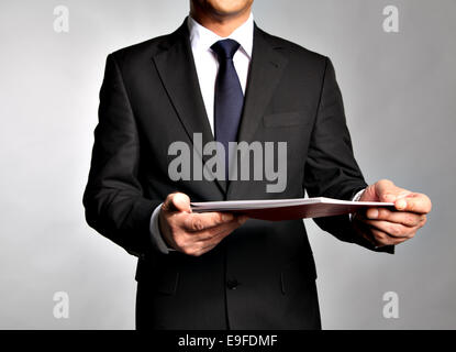 Geschäftsmann hält eine Broschüre Stockfoto