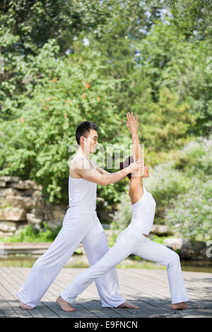 Yoga-Lehrer hilft Frau mit pose Stockfoto