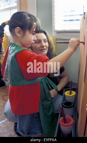 Kindergarten-Assistentin, die Malerei mit Kind Stockfoto