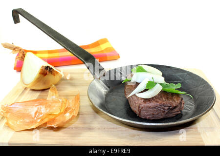 ein Stück Fleisch in einer Eisenpfanne Stockfoto
