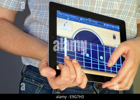 Tambow, Russische Föderation - 20. Januar 2013 Frauenhand Gitarre mit GarageBand App auf dem Apple iPad. Stockfoto