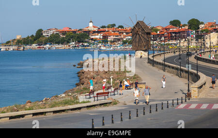 Nessebar, Bulgarien - 21. Juli 2014: Küstenlandschaft mit Straßen- und alte Windmühle, Schwarzmeer-Küste im sonnigen Tag. Touristen gehen auf Stockfoto