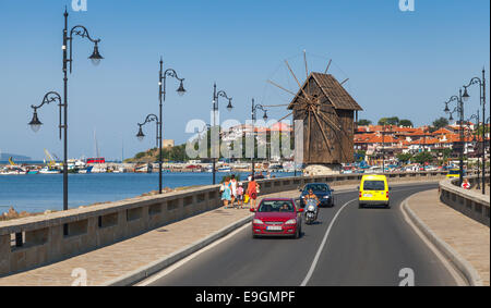 Nessebar, Bulgarien - 21. Juli 2014: Küstenstraße und alte hölzerne Windmühle. Antike Stadt Nessebar, Bulgarien. Schwarzmeer-Küste in sunn Stockfoto