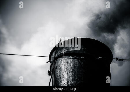 Detailansicht des Schornsteins Dampf Zug. Schwarzer Rauch kommt aus einem Schornstein. Schwarz / weiß Fotografie Stockfoto
