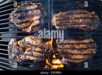 Steaks auf dem Grill, über Flamme gegrillt wird Char. Stockfoto