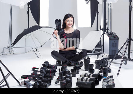 Fotograf im Studio mit vielen Kameras auf dem Boden Stockfoto