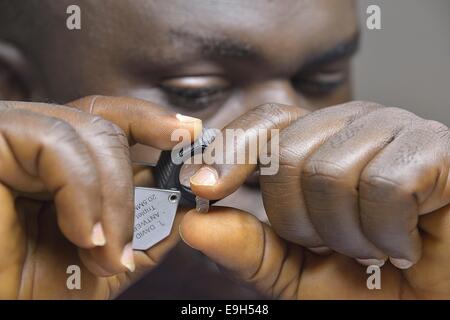 Diamanthändler betrachten eines Diamanten durch ein Vergrößerungsglas, Koidu, Koidu-Sefadu, Kono District, Eastern Province Stockfoto