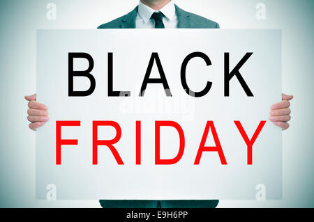 ein Mann in einem Anzug hält ein Schild mit den Worten schwarzen Freitag geschrieben Stockfoto