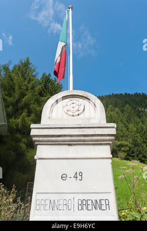 Staatliche Grenze am Brenner Pass, alte Grenzstein zwischen Italien und Österreich mit der italienischen Nationalflagge, Brenner Stockfoto