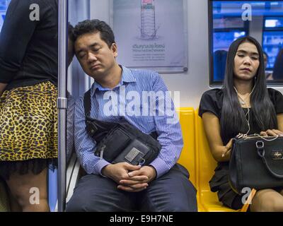 Bangkok, Thailand. 28. Oktober 2014. Passagiere schlafen auf die Silom Linie des Bangkok Skytrain. Zwar gibt es zwei Gleise für die meisten Strecken des Systems der Skytrain, die Teil der Silom-Linie auf der Saphan Taksin Brücke überspannt den Fluss Chao Phraya hat nur eine Spur aus Platzgründen einen Engpass verursacht, wenn eine ausgehende und eingehende an der Brücke zur gleichen Zeit ankommen. Bildnachweis: ZUMA Press, Inc./Alamy Live-Nachrichten Stockfoto