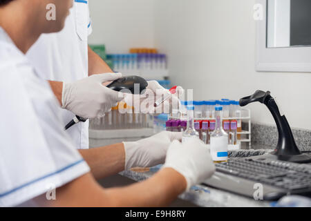 Techniker, die Proben mit Barcode-Scanner scannen Stockfoto