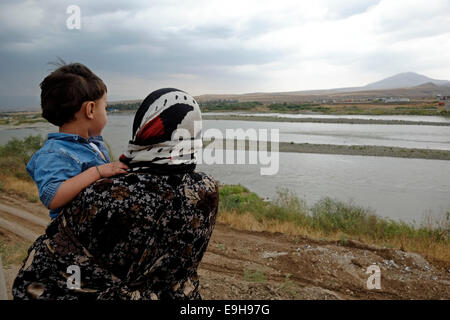 Eine kurdische Mutter und ihr Kind von der syrischen Seite der Tigris am Khabur Faysh oder Fishkhabur - Semalka Grenzübergang aus Nordosten Syriens kurdischen Gebiet in der Irakischen Region Kurdistan blicken. Stockfoto