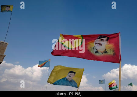 Flags, die das Bild von Abdullah Öcalan Gründungsmitglied der militanten Organisation der Arbeiterpartei Kurdistans (PKK) im Wind flattern in al-Hasaka oder Hassakeh im Landkreis Rojava der De-facto-kurdische autonome Region mit Ursprung in und aus drei selbständigen Gemeinden im nördlichen Syrien Stockfoto