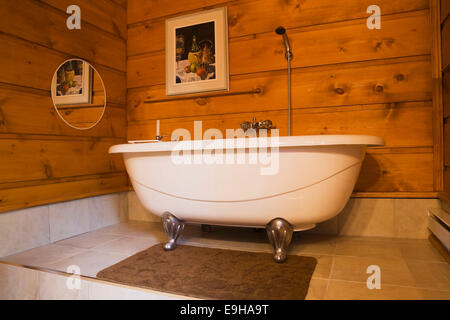 Roll-Top Badewanne in einem Badezimmer in einer Canadiana Hütte, eine weiße Kiefer Blockhaus, Provinz Quebec, Kanada Stockfoto