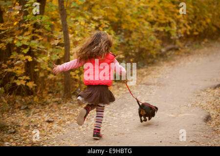 Kleines Kind laufen und gehen mit einem Dackel-Welpen. Liebe zu Tieren Konzept Stockfoto