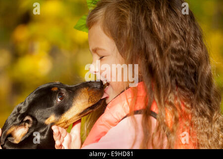Kleinen Kind küssen Dackel Welpen. Liebe zu Tieren Konzept Stockfoto