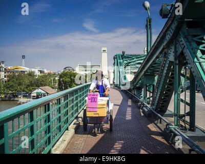 Bangkok, Bangkok, Thailand. 28. Oktober 2014. Ein Kreditor schiebt seinen Wagen über Memorial Bridge über den Chao Phraya River in Bangkok. Die Brücke verbindet die Bangkok und Thonburi Seite des Flusses. © Jack Kurtz/ZUMA Draht/Alamy Live-Nachrichten Stockfoto