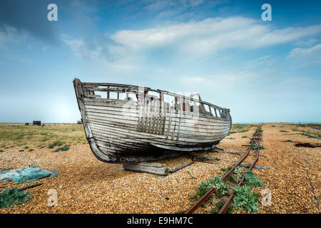 Einem alten Holzboot neben einer Bahntrasse auf einem Kiesstrand Stockfoto