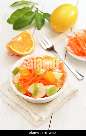 Obstsalat in Schüssel auf weißer Holztisch. Gesundes Frühstück. Stockfoto