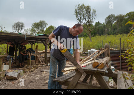 Mann Sägen Kastanien Einsätze auf Größe in einer Werkstatt in einem Waldgebiet löschen. Stockfoto