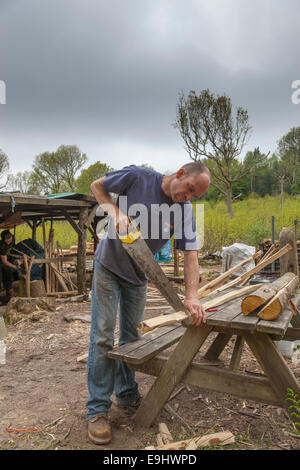 Mann Sägen Kastanien Einsätze auf Größe in einer Werkstatt in einem Waldgebiet löschen. Stockfoto