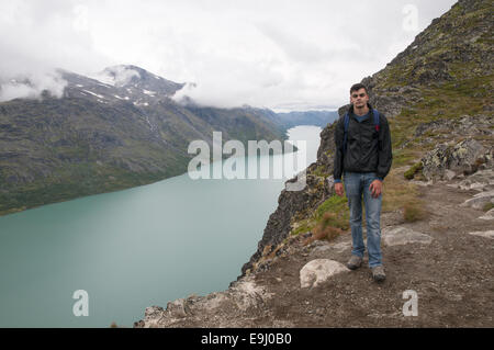 Junge Wanderer nähert sich Besseggen Bergrücken mit Blick über Gjende See, Nationalpark Jotunheimen, Oppland, Norwegen Stockfoto