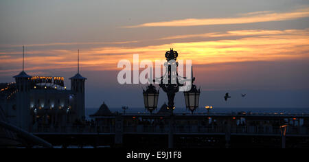 Brighton, Sussex, UK. 28. Oktober 2014. -UK Wetter. Die Sonne versinkt hinter dem Pier in Brighton nach einem warmen sonnigen Tag an der Küste Credit: Simon Dack/Alamy Live News Stockfoto