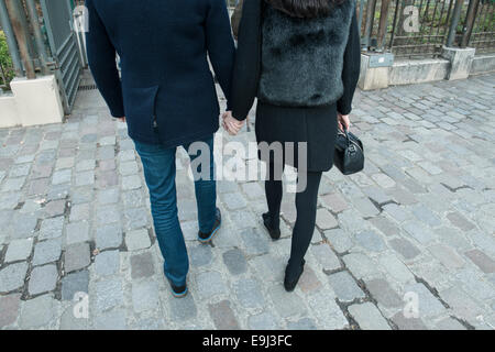 Ein junges Paar in der Liebe halten Hände beim Gehen bis eine Pariser Straße in Richtung Liebe Mauer Reiseziel in Paris am Valentines Tag Stockfoto