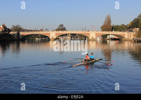 Themse, SW-London, UK. 28. Oktober 2014. Einen schönen und warmen Herbstmorgen an der Themse in Hampton Court. Zwei Dame Ruderer nähern Hampton Court Brücke spiegelt sich in den ruhigen Gewässern. Bildnachweis: Julia Gavin UK/Alamy Live-Nachrichten Stockfoto