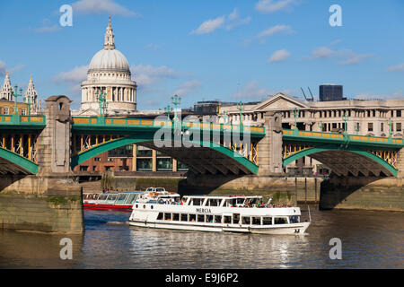 Fluss-Busse fahren Sie unter Southwark Bridge an der Themse mit St. Pauls Kathedrale im Hintergrund, London, UK Stockfoto