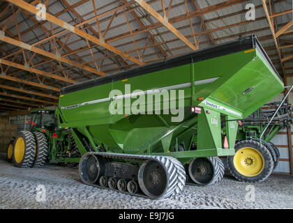 Unverferth 1315 Getreide Wagen mit Tracks in einer Scheune Ausrüstung; Es ist ein John Deere Traktor beigefügt. Stockfoto