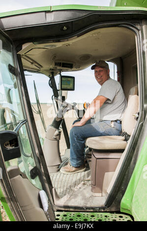 reifer Mann sitzen in der Kabine von einem John Deere S670 kombinieren vorbereiten, ein Feld von Sojabohnen zu ernten. Stockfoto