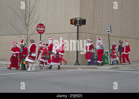 Eine Packung Weihnachtsmänner, Frau. Klauseln und Elfen eine Straße in der Innenstadt von Asheville um Weihnachten während der Veranstaltung santacon Kreuz Stockfoto
