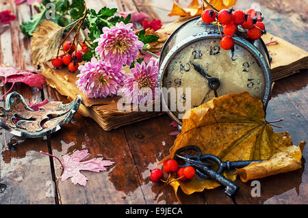 alte Uhr auf dem Hintergrund der gefallenen Blätter Stockfoto