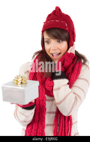 Überrascht junge Frau hält ein verpacktes Geschenk Stockfoto