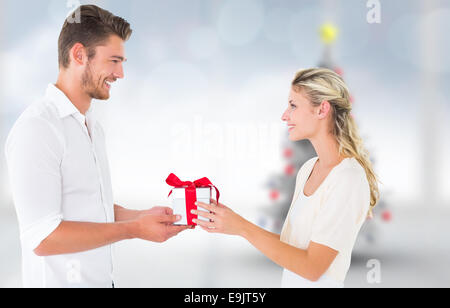 Zusammengesetztes Bild des jungen Paares mit Geschenk Stockfoto