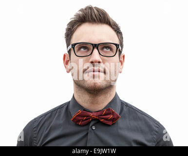 Frontale Porträt eines jungen Mannes mit Brille auf der Suche nach oben links, isoliert auf einem weißen Hintergrund. Stockfoto