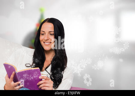 Zusammengesetztes Bild des lächelnden Frau liest ein Buch Stockfoto