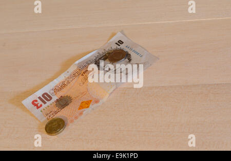 Eine britische zehn-Pfund-Note mit Münzen an der Spitze. Stockfoto