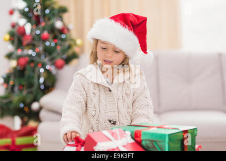 Niedliche kleine Mädchen umgeben von Weihnachtsgeschenke Stockfoto