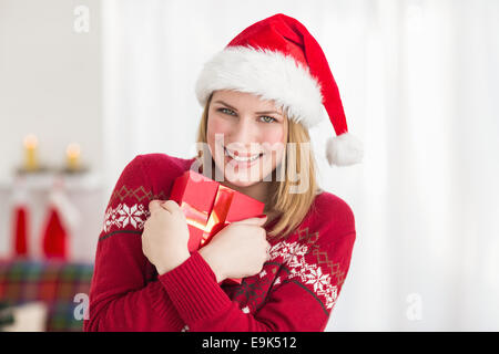 Festliche hübsche Frau umarmt ihr Geschenk Stockfoto