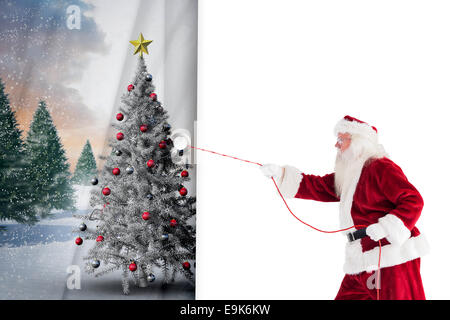 Zusammengesetztes Bild des Weihnachtsmanns zieht etwas mit einem Seil Stockfoto